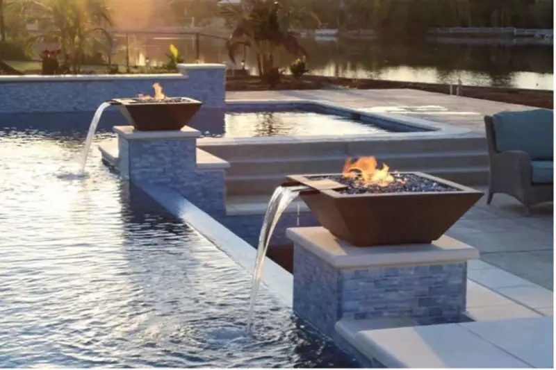 Fire bowls and water spouts on a pool edge