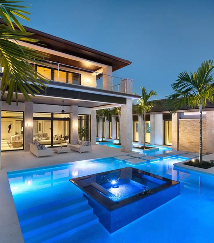 A clean pool and spa beside a modern house