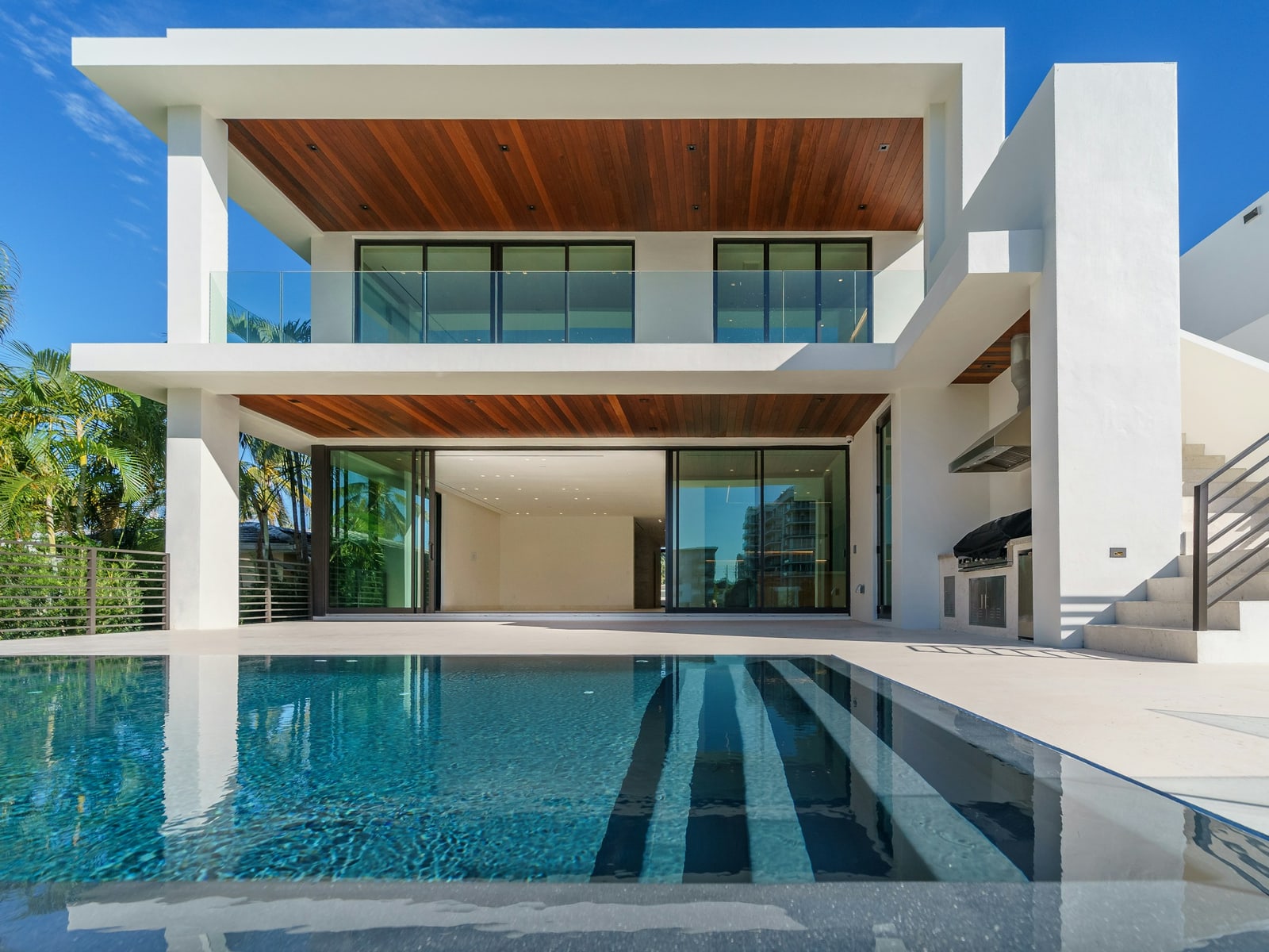 Bright blue pool in front of a modern white villa