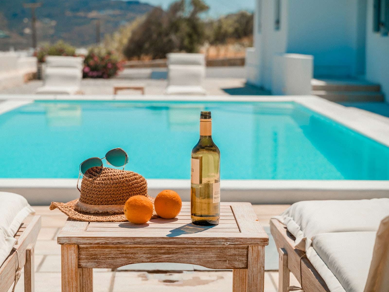 Turquoise pool with white loungers on a sunny terrace