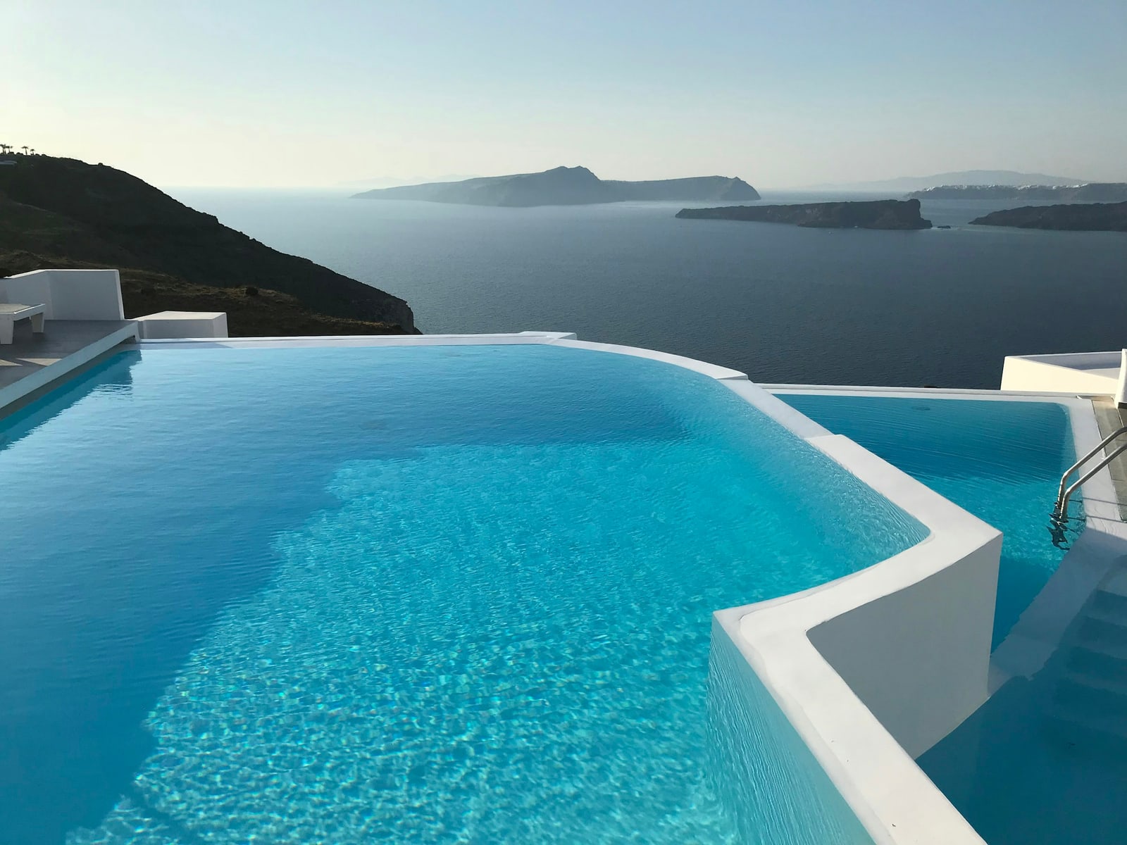 Bright blue infinity-edge pool above the sea