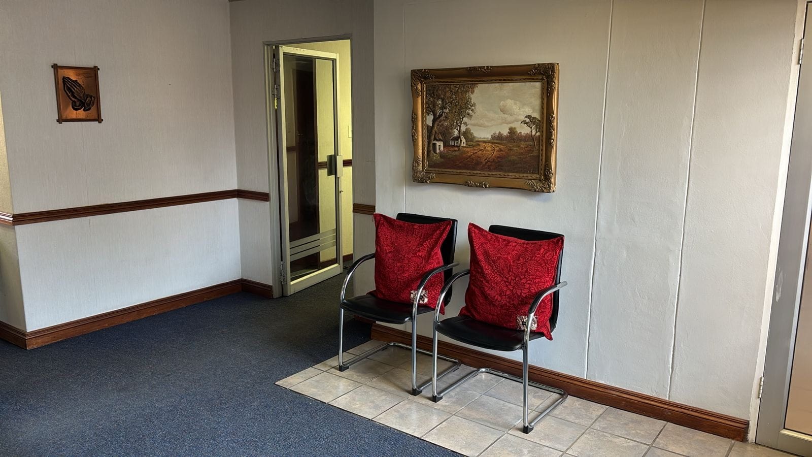 Entrance area with two visitor chairs beside the glass front door