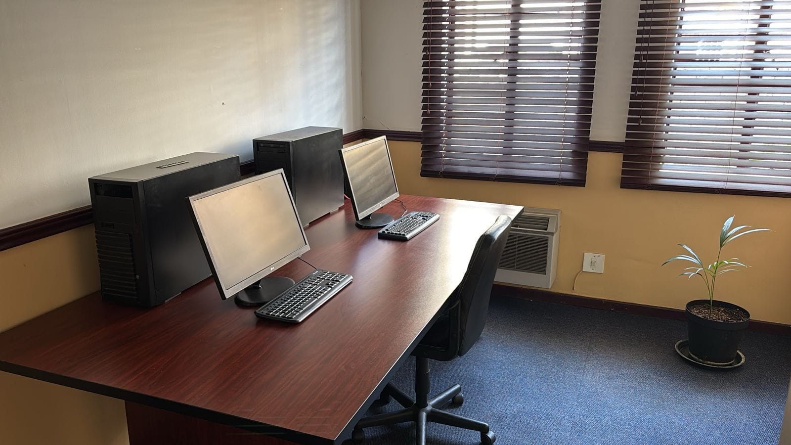 Office workstation with two monitors and desktop computers