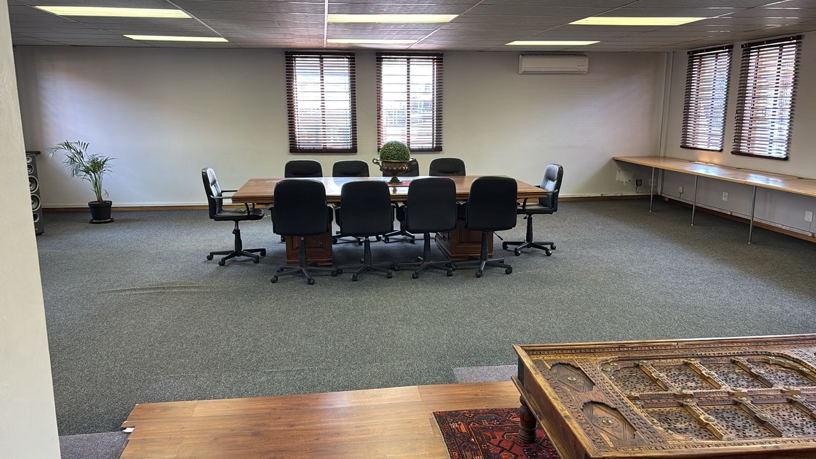 Spacious meeting room with an eight-seater table and a long side counter