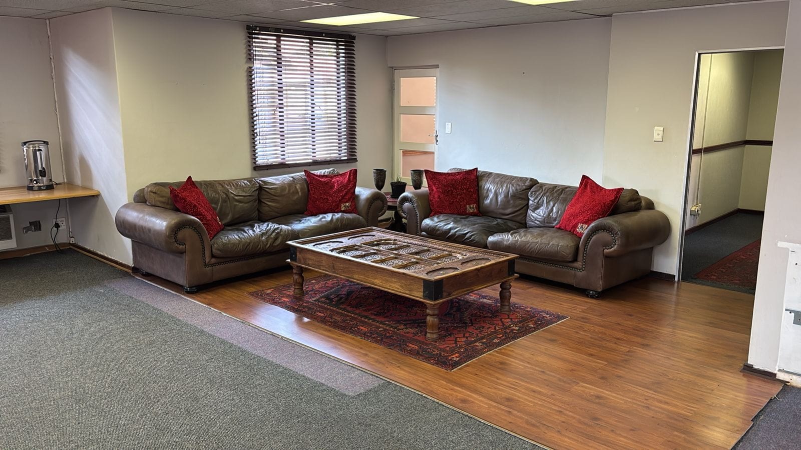 Lounge area with two leather couches around a carved wooden coffee table