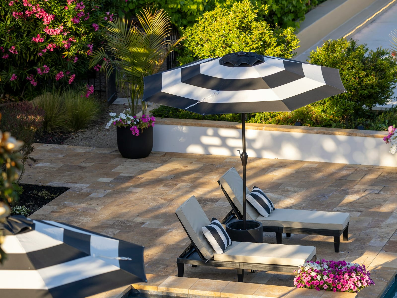 A pool deck with a spa and loungers