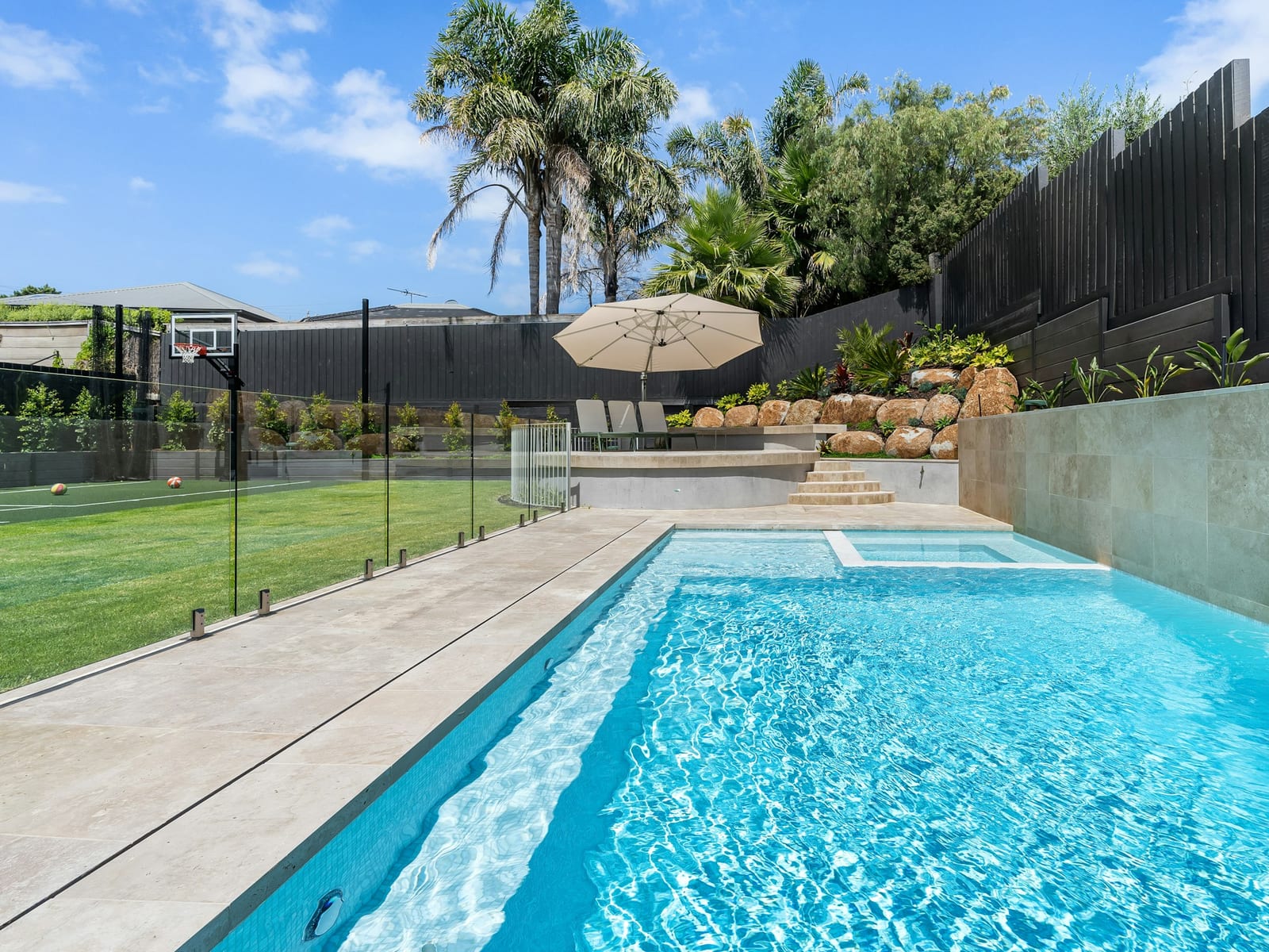 A pool behind frameless glass safety fencing